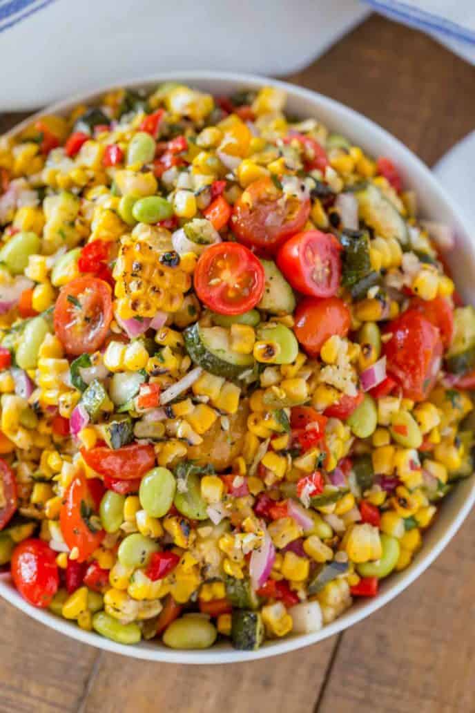 Corn Succotash is the perfect summer side dish made with freshly grilled corn, zucchini, grape tomatoes, red bell peppers, lima beans and red onion. | #summer #sides #sidedish #picnic #dinnerthendessert #easysidedish #vegetarian #corn