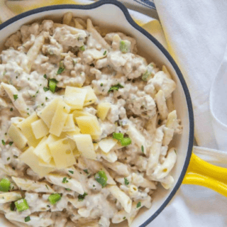 pasta in a yellow skillet topped with swiss cheese