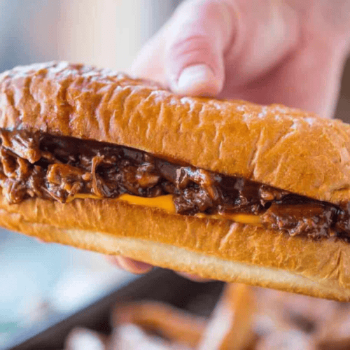 Hand holding a sandwich with Beef