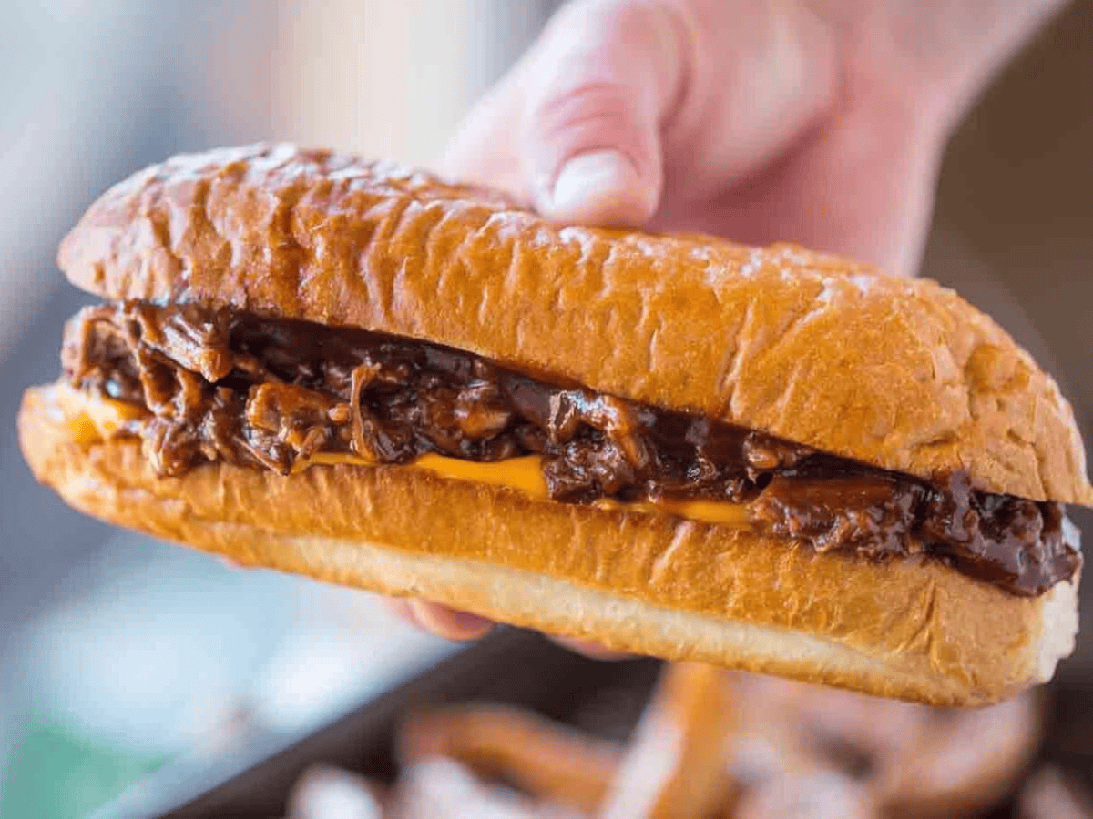 Hand holding a sandwich with Beef