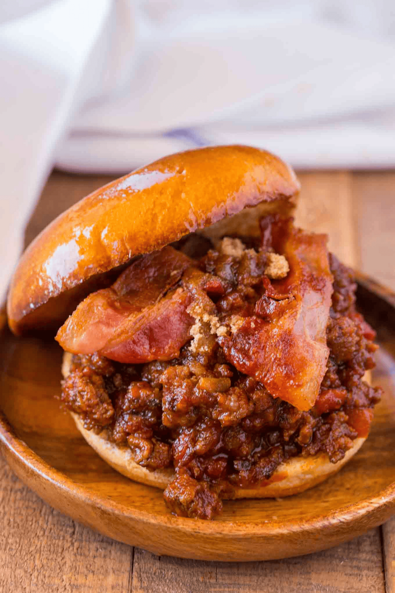 Open sloppy joe sandwich on a wooden plate