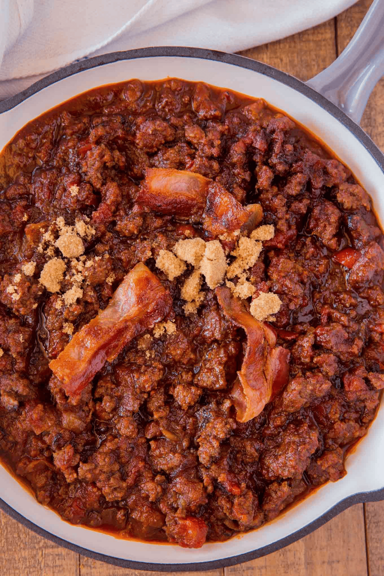 Sloppy joe mixture in a pan topped with bacon and brown sugar