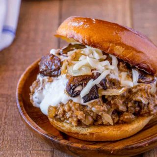 ground meat covered in chili with cheese inside of two buns