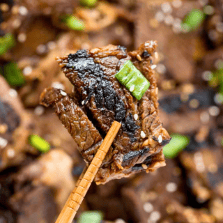 piece of sweet beef between chopsticks