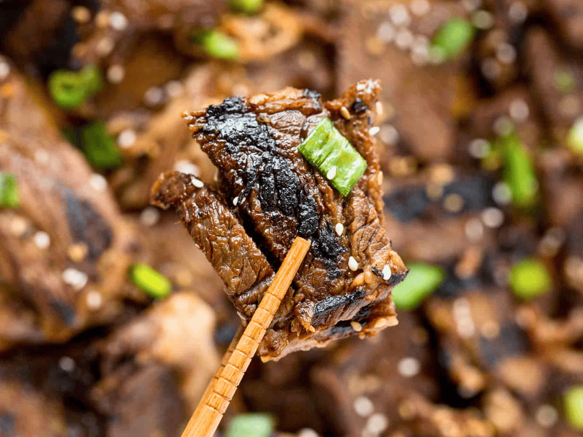 piece of sweet beef between chopsticks