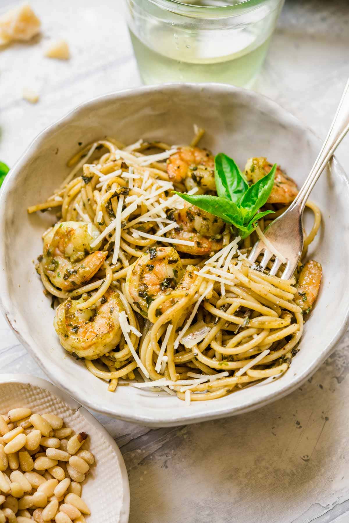 Shrimp Pesto Pasta with Basil Pesto cooked shrimp in bowl with pasta and parmesan cheese