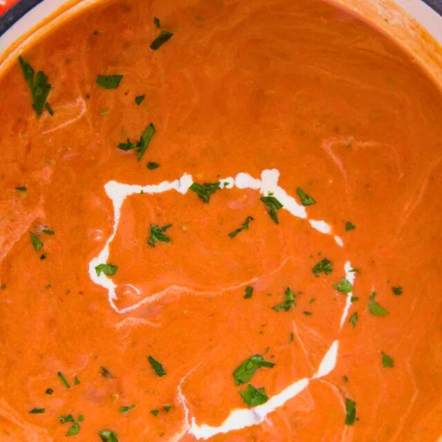 Soup in a pot with drizzle of cream on top