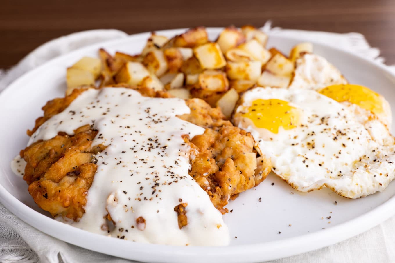 Chicken Fried Steak on plate with eggs and hash browns