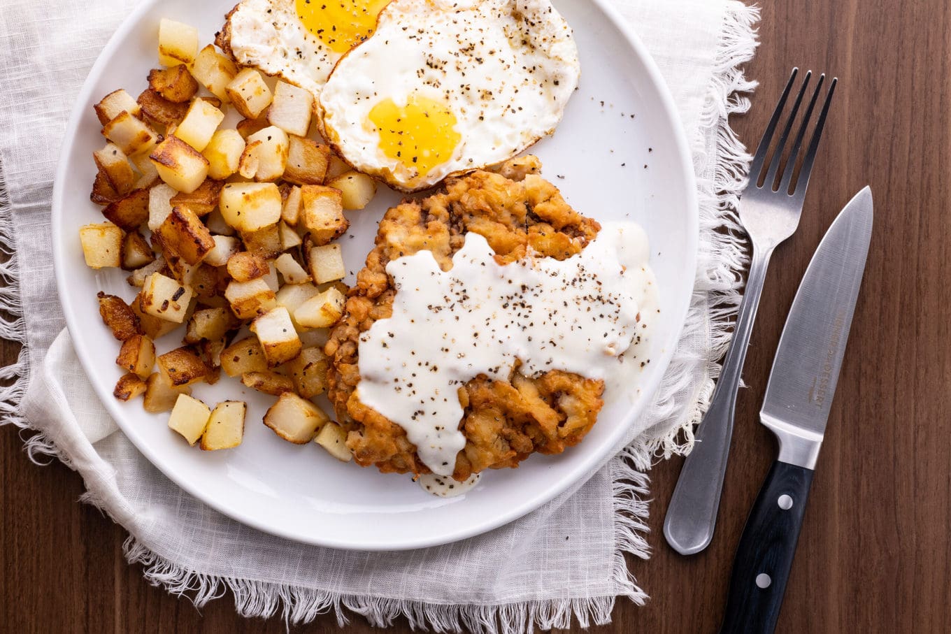 Chicken Fried Steak on plate with eggs and hash browns