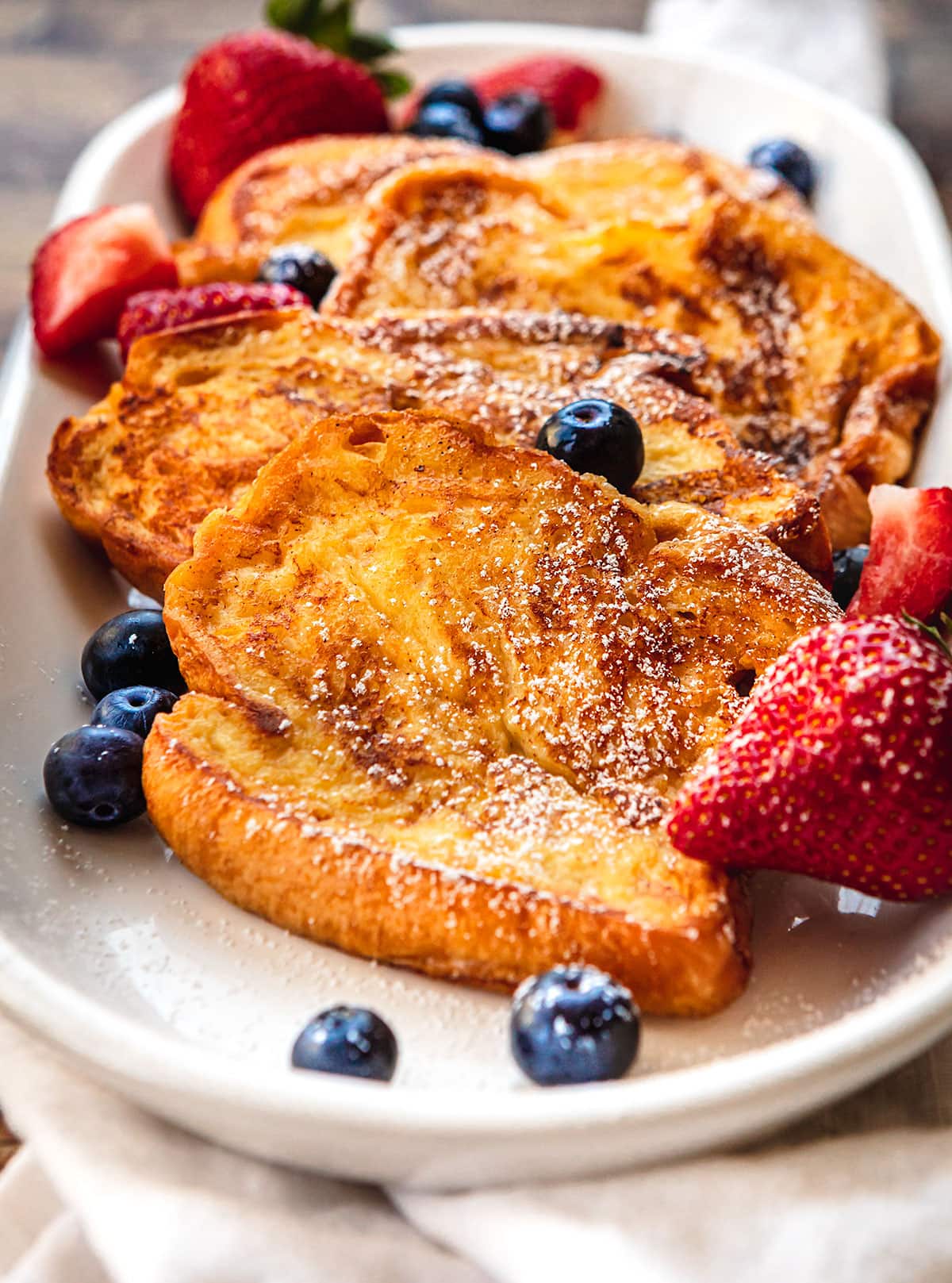 French Toast on plate with strawberries and blueberries