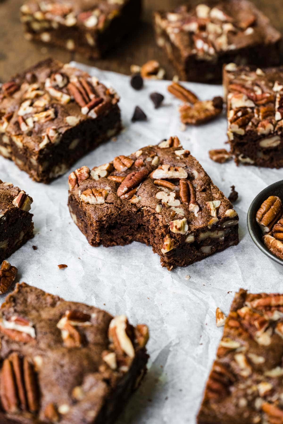 Pecan Brownies squares on parchment with bite taken