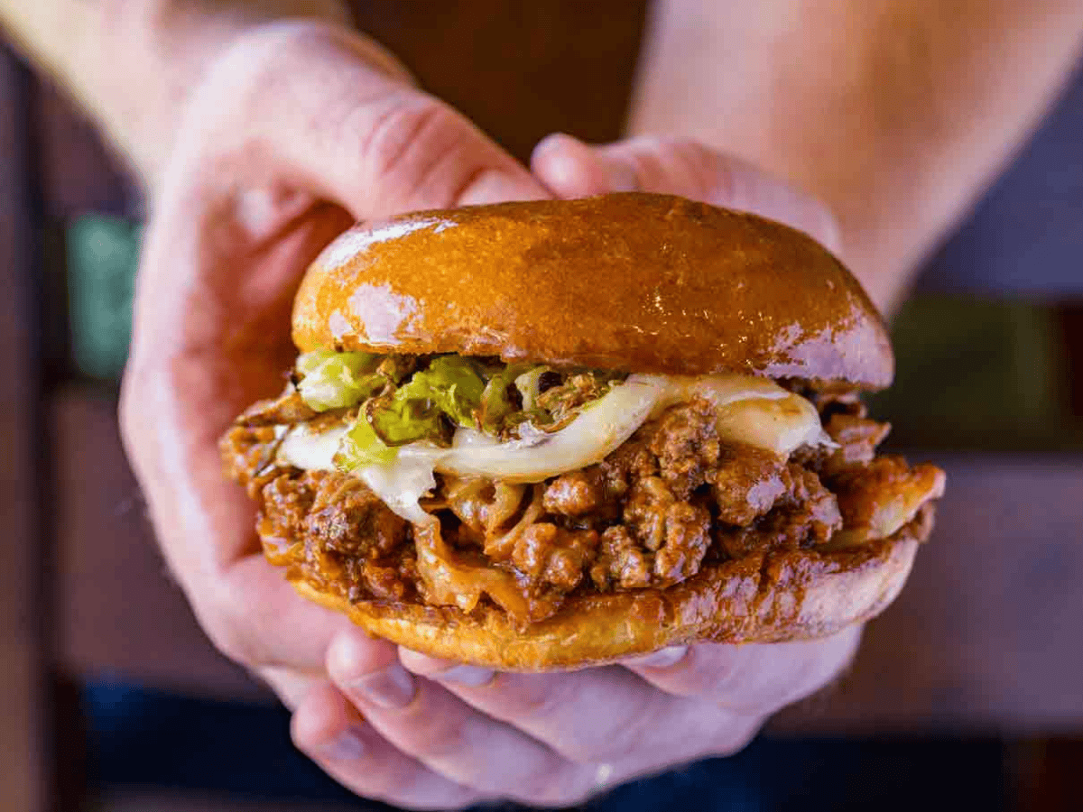 Hands Holding Sloppy Joes Sandwich with cabbage