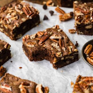 Pecan Brownies squares on parchment with bite taken