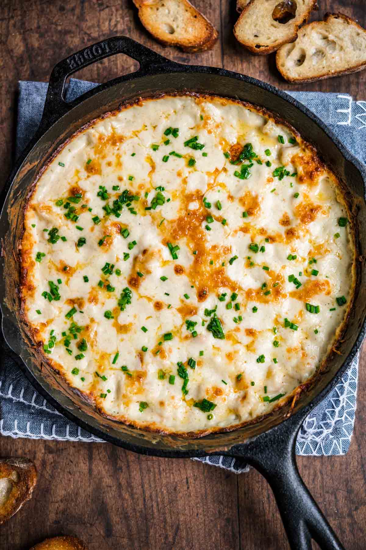 Garlic Shrimp Dip shrimp in skillet after baking with melted cheese and parsley garnish