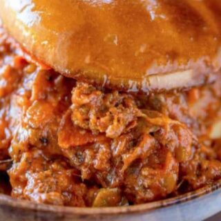 Sloppy Joe in a bun on a wooden plate.