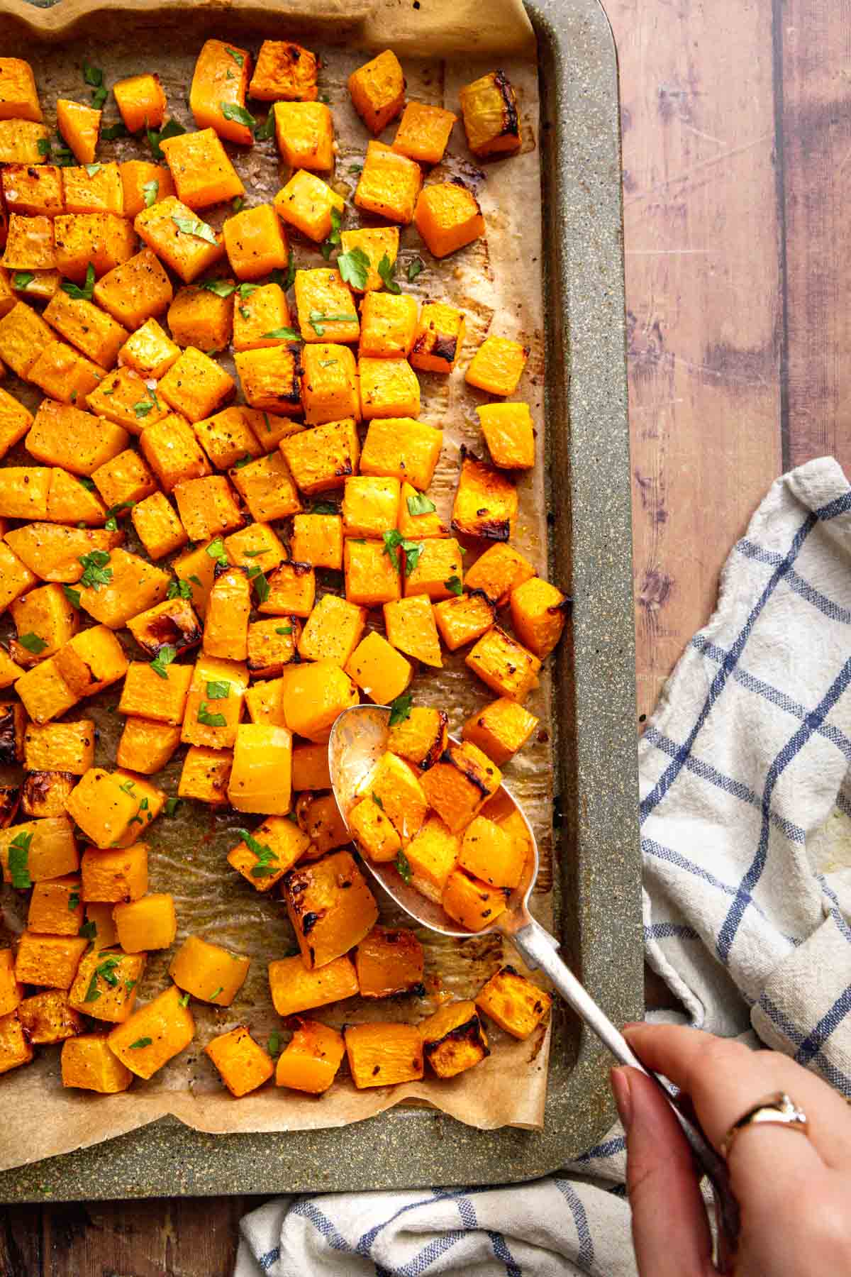 Roasted Butternut Squash ingredients spooning from baking sheet