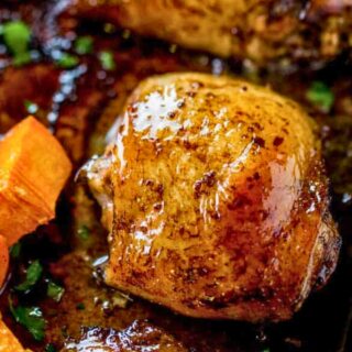 Roasted chicken thigh and sweet potatoes on a baking sheet