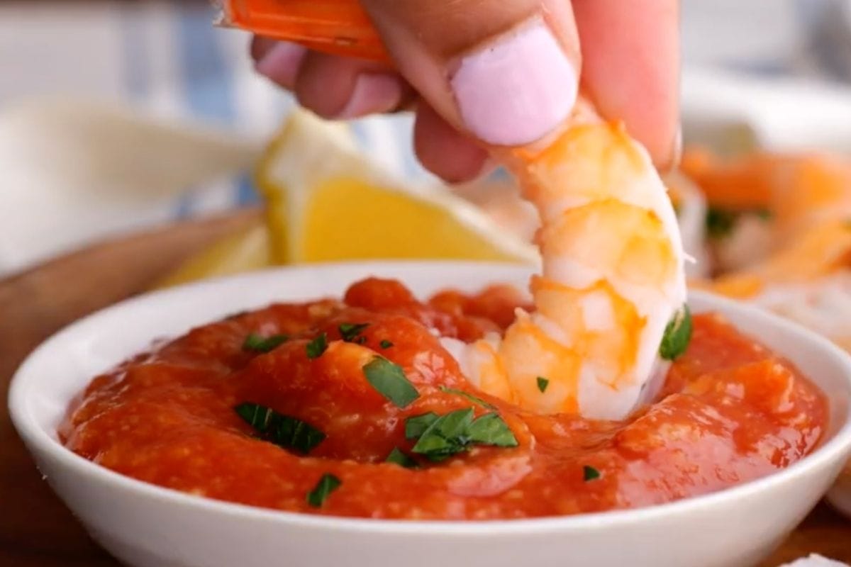 Shrimp Cocktail piece being dipped in sauce