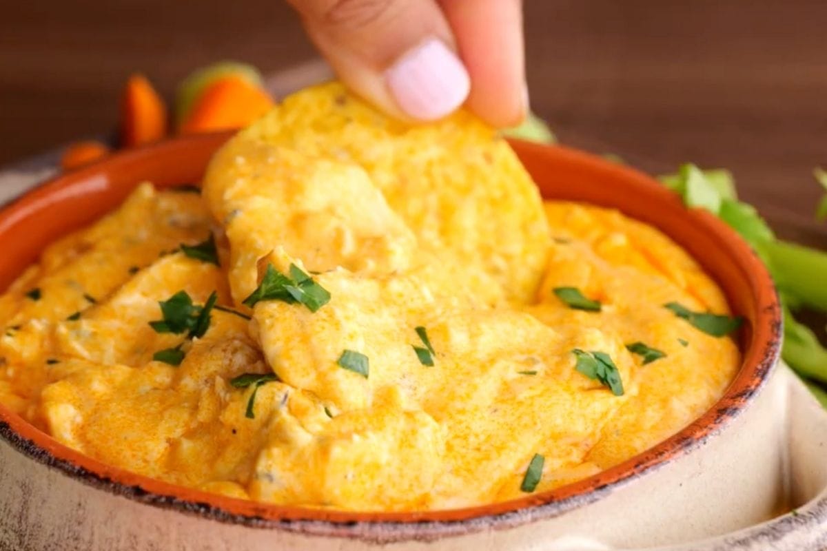 Slow Cooker Buffalo Chicken Dip with hand dipping chip