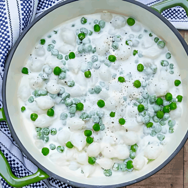 Creamy onions and peas in a pot