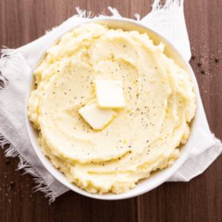 Potatoes in a serving bowl with butter garnishment