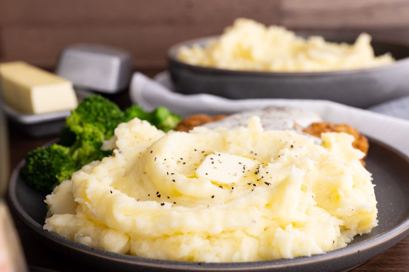 Easy Mashed Potatoes on plate with butter and pepper