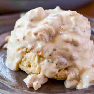 biscuit on a silver plate with gravy on top 4x3