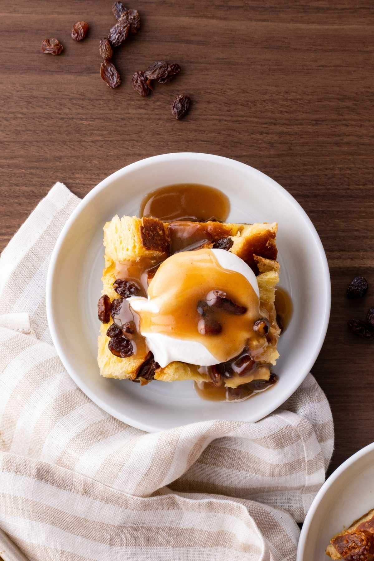 Bread Pudding in bowl with whipped cream and caramel sauce
