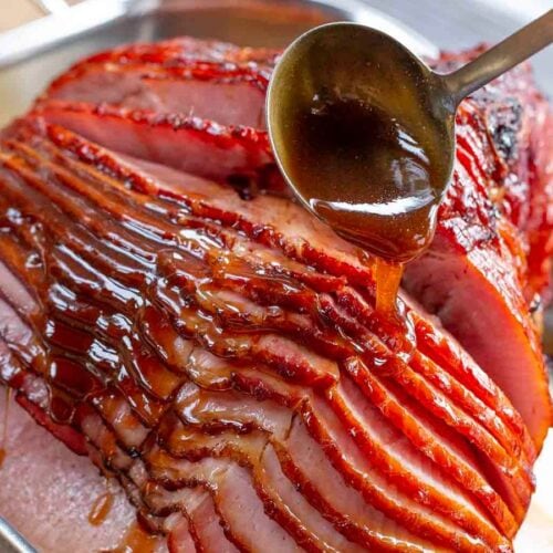 ladling glaze over spiral ham in pan