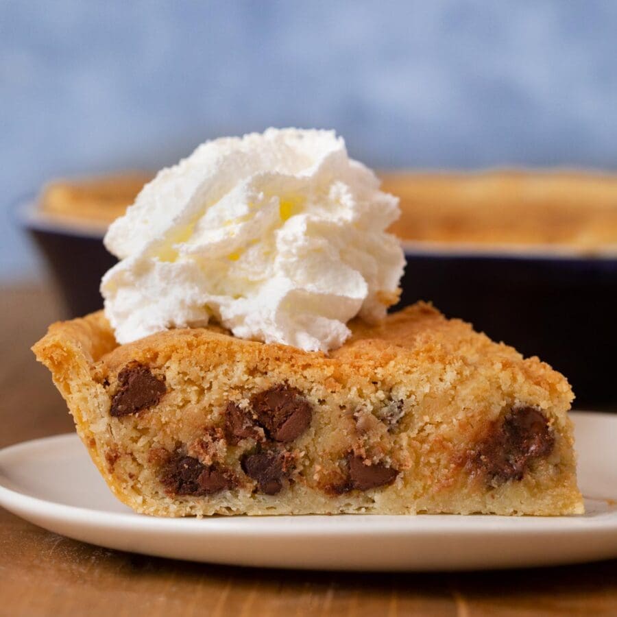 Chocolate Chip Cookie Pie slice on plate with whipped cream