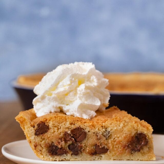 Chocolate Chip Cookie Pie slice on plate with whipped cream