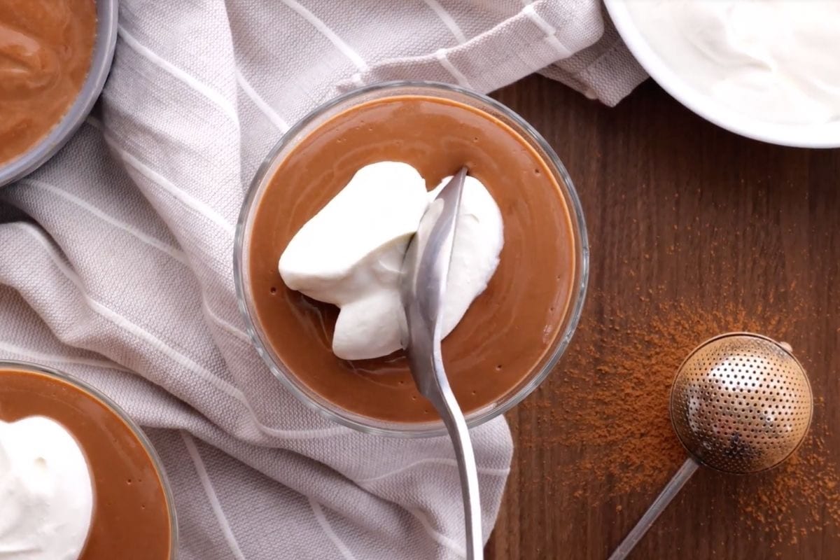 Chocolate Pudding in dessert dish with whipped cream and spoon