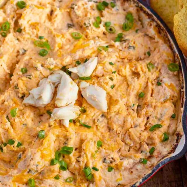 Creamy dip in a skillet with crostini on the side
