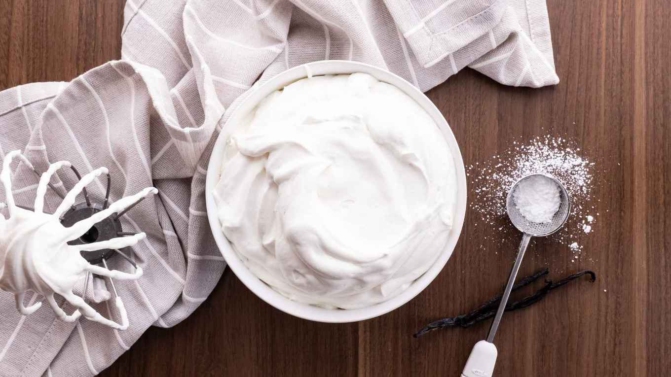 Whipped Cream in bowl with whisk mix attachment and powdered sugar