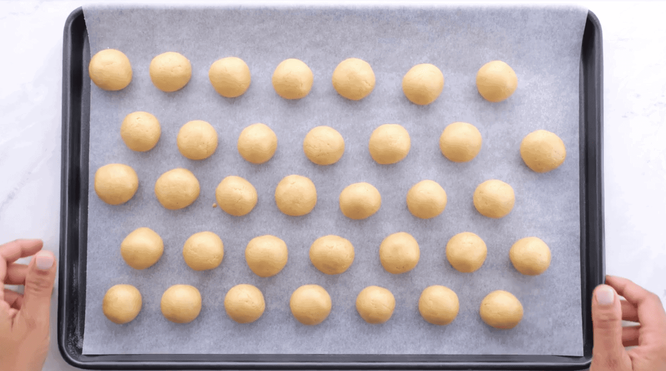 Peanut butter balls on a parchment-lined sheet