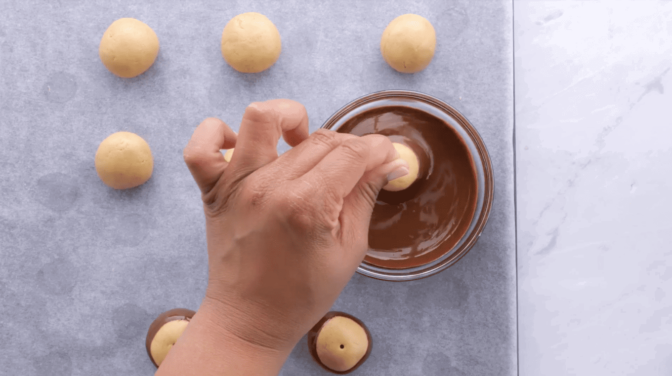 Dipping peanut butter balls in melted chocolate