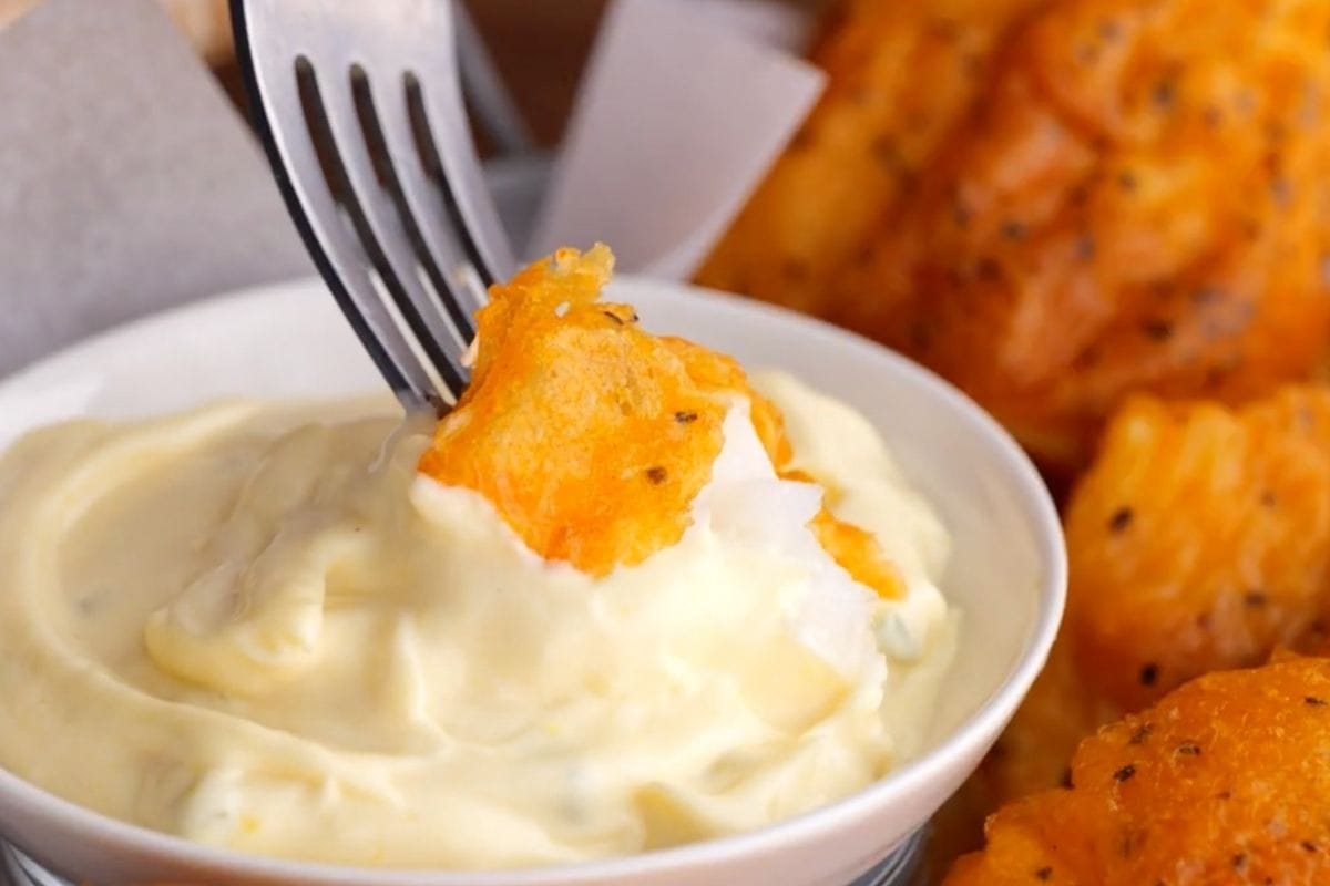 Beer Battered Fish piece dipped in tartar sauce