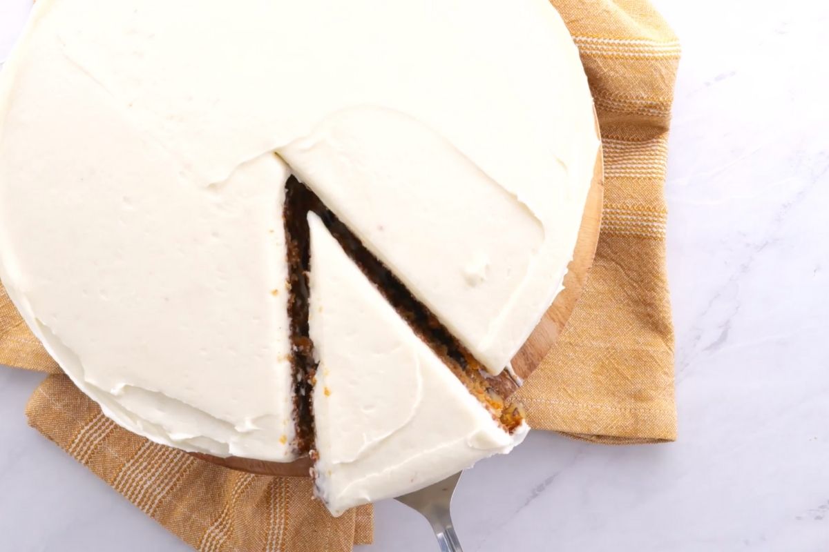 Classic Carrot Cake slice being lifted from whole cake