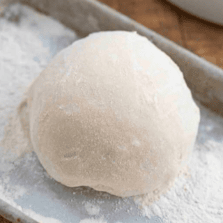 Flour on dough in a ball on baking sheet