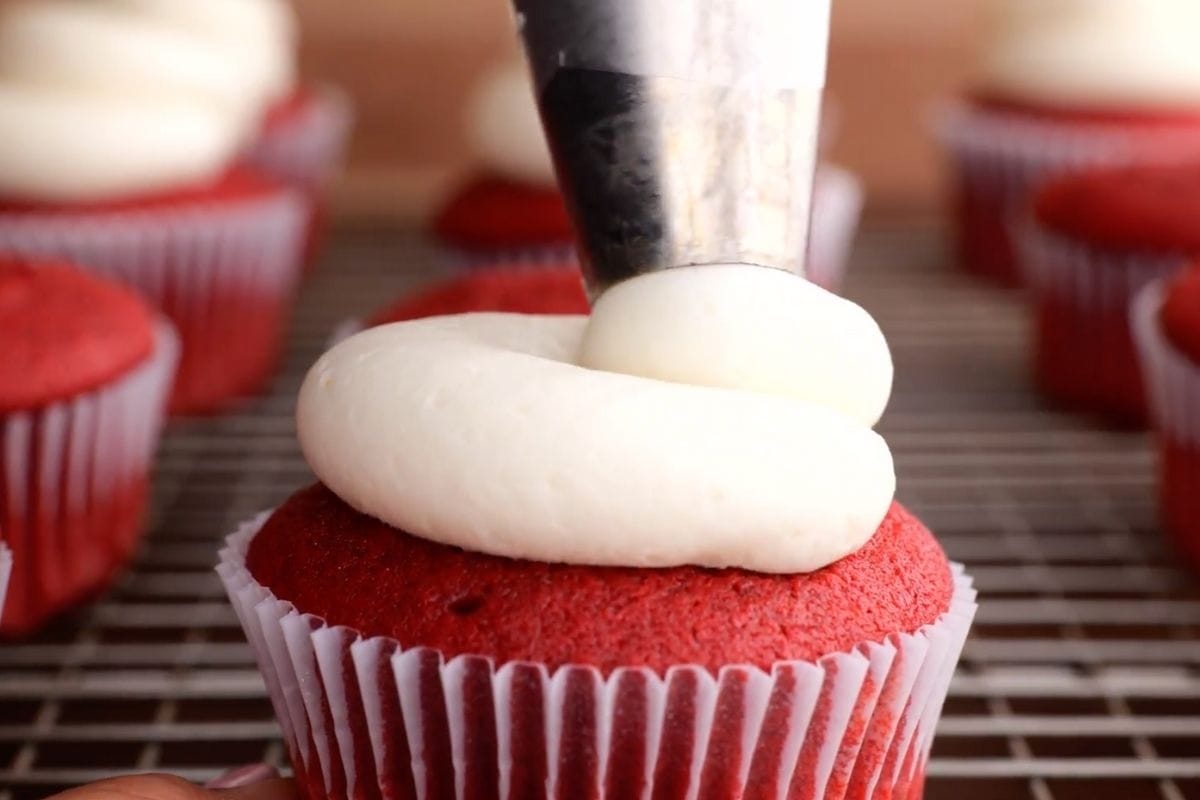 Red Velvet Cupcakes with frosting being piped