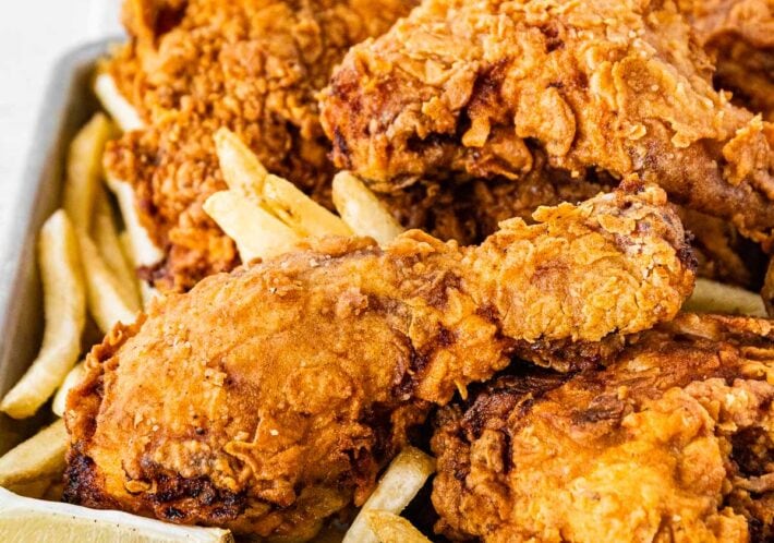 Super Crispy Fried Chicken with french fries and lemon wedge