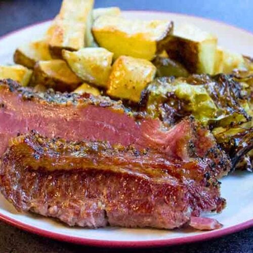 Plated slices of corned beef with potatoes and cabbage