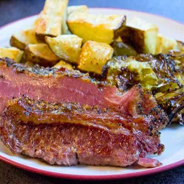 Plated slices of corned beef with potatoes and cabbage