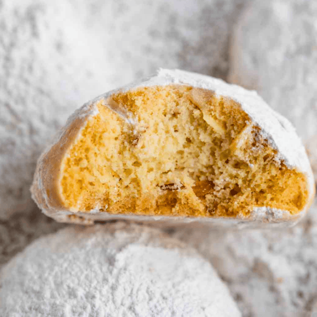 cookie covered in white powdered sugar bitten in half