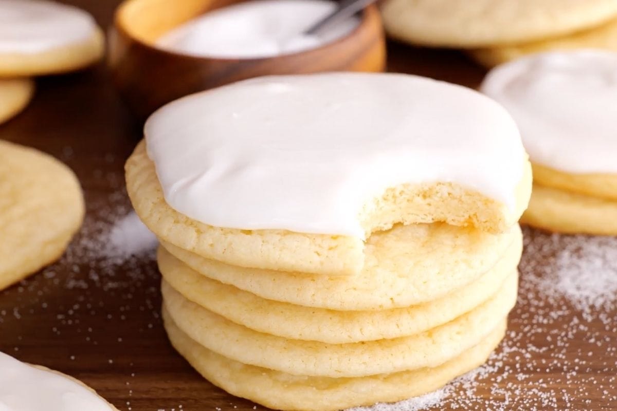 Rolled Sugar Cookies in stack with buttercream icing and bite taken