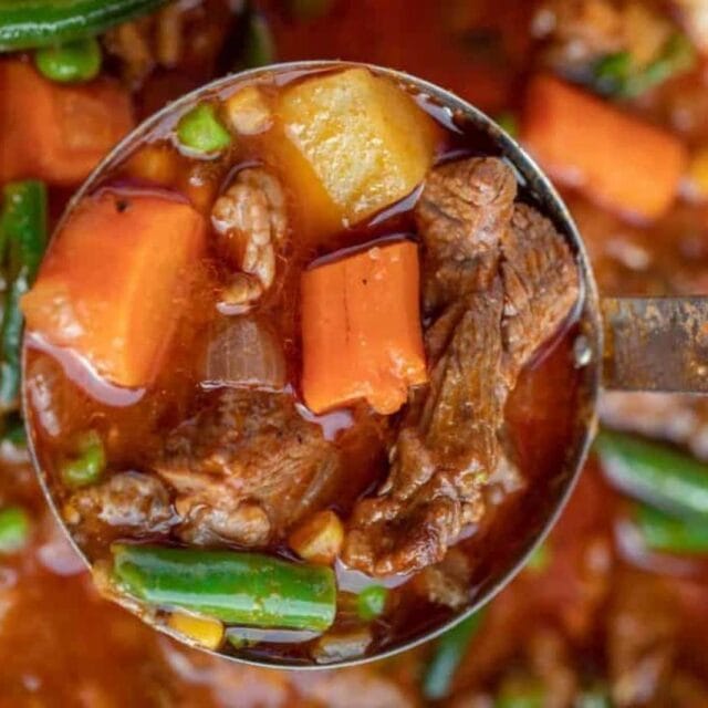 Ladle holding stew over a pot