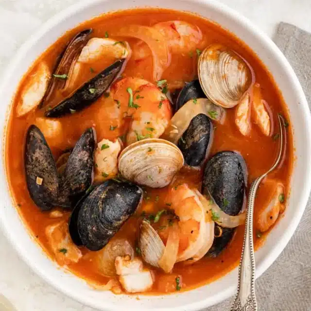 Bowl of tomato based soup with clams and mussels.