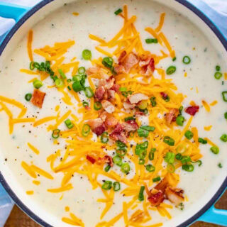 creamy potato soup garnished with cheese, bacon and onion