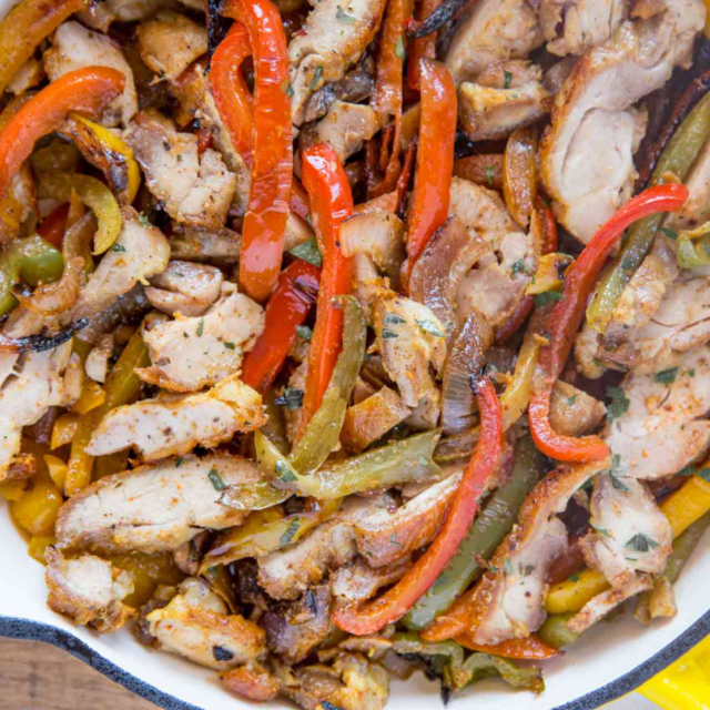 chicken and vegetable mixture in yellow cast iron skillet