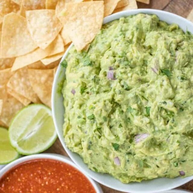 guacamole with chips and lime garnishment
